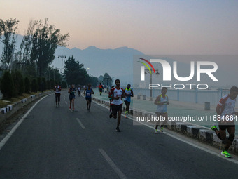 Participants run during the Kashmir Marathon on the banks of Dal Lake in Srinagar, Jammu and Kashmir, on October 20, 2024. Kashmir hosts its...