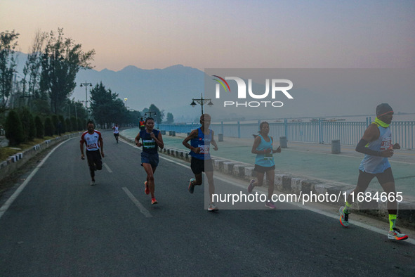 Participants run during the Kashmir Marathon on the banks of Dal Lake in Srinagar, Jammu and Kashmir, on October 20, 2024. Kashmir hosts its...