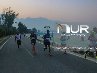 Participants run during the Kashmir Marathon on the banks of Dal Lake in Srinagar, Jammu and Kashmir, on October 20, 2024. Kashmir hosts its...