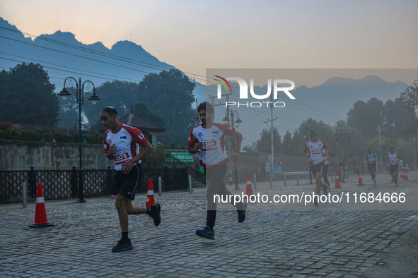 Participants run during the Kashmir Marathon on the banks of Dal Lake in Srinagar, Jammu and Kashmir, on October 20, 2024. Kashmir hosts its...