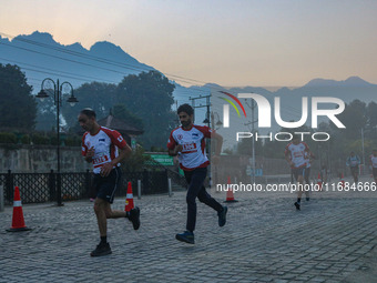 Participants run during the Kashmir Marathon on the banks of Dal Lake in Srinagar, Jammu and Kashmir, on October 20, 2024. Kashmir hosts its...