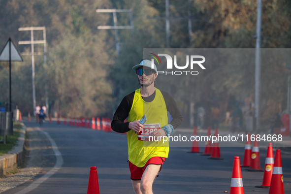 A participant runs during the Kashmir Marathon on the banks of Dal Lake in Srinagar, Jammu and Kashmir, on October 20, 2024. Kashmir hosts i...