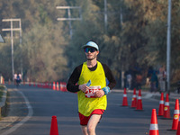 A participant runs during the Kashmir Marathon on the banks of Dal Lake in Srinagar, Jammu and Kashmir, on October 20, 2024. Kashmir hosts i...