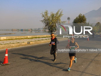 Participants run during the Kashmir Marathon on the banks of Dal Lake in Srinagar, Jammu and Kashmir, on October 20, 2024. Kashmir hosts its...