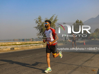 Participants run during the Kashmir Marathon on the banks of Dal Lake in Srinagar, Jammu and Kashmir, on October 20, 2024. Kashmir hosts its...