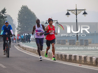 Participants run during the Kashmir Marathon on the banks of Dal Lake in Srinagar, Jammu and Kashmir, on October 20, 2024. Kashmir hosts its...