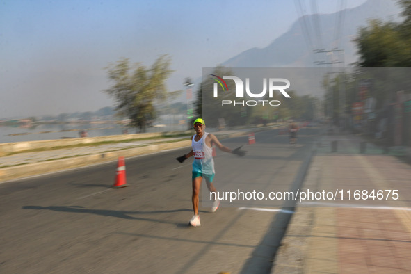 A participant runs during the Kashmir Marathon on the banks of Dal Lake in Srinagar, Jammu and Kashmir, on October 20, 2024. Kashmir hosts i...