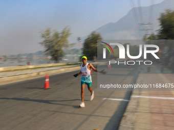 A participant runs during the Kashmir Marathon on the banks of Dal Lake in Srinagar, Jammu and Kashmir, on October 20, 2024. Kashmir hosts i...