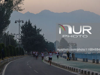 Participants run during the Kashmir Marathon on the banks of Dal Lake in Srinagar, Jammu and Kashmir, on October 20, 2024. Kashmir hosts its...