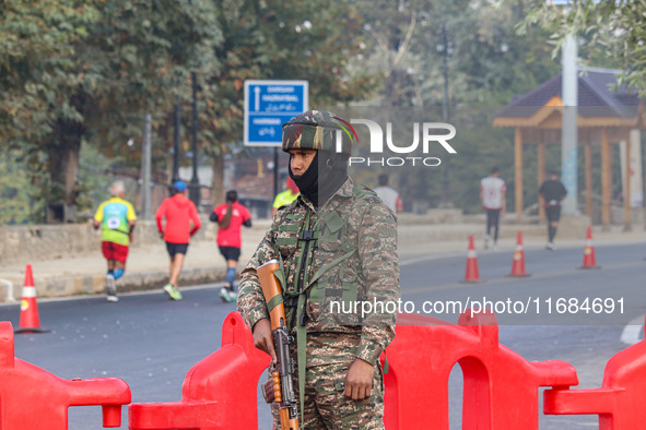 An Indian paramilitary soldier stands alert during the Kashmir Marathon in Srinagar, Jammu and Kashmir, on October 20, 2024. Kashmir hosts i...