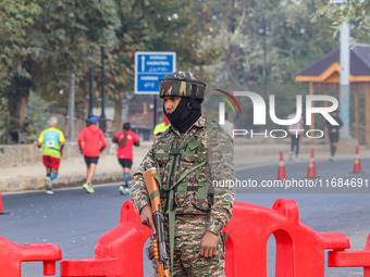 An Indian paramilitary soldier stands alert during the Kashmir Marathon in Srinagar, Jammu and Kashmir, on October 20, 2024. Kashmir hosts i...