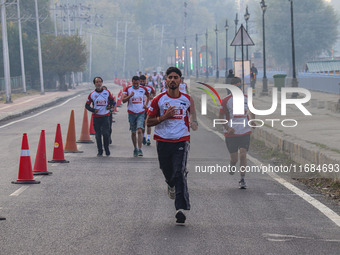 Participants run during the Kashmir Marathon on the banks of Dal Lake in Srinagar, Jammu and Kashmir, on October 20, 2024. Kashmir hosts its...