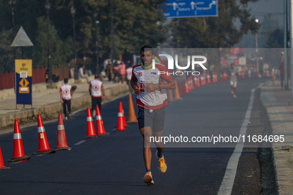 A participant runs during the Kashmir Marathon on the banks of Dal Lake in Srinagar, Jammu and Kashmir, on October 20, 2024. Kashmir hosts i...