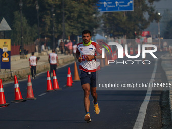 A participant runs during the Kashmir Marathon on the banks of Dal Lake in Srinagar, Jammu and Kashmir, on October 20, 2024. Kashmir hosts i...