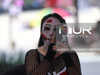 A woman applies makeup while participating in the annual Zombie Walk 2024 from the Monument to the Revolution to the main square Zocalo in M...