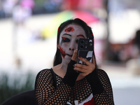 A woman applies makeup while participating in the annual Zombie Walk 2024 from the Monument to the Revolution to the main square Zocalo in M...