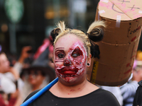 A person in disguise takes part in the annual Zombie walk from the Monument to the Revolution to the main square Zocalo in Mexico City, Mexi...