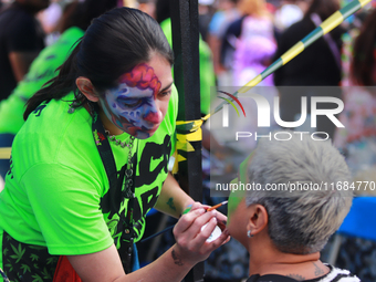 A woman applies makeup to a person during the annual Zombie Walk 2024 Mx, from the Monument to the Revolution to the main square Zocalo in M...