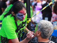 A woman applies makeup to a person during the annual Zombie Walk 2024 Mx, from the Monument to the Revolution to the main square Zocalo in M...