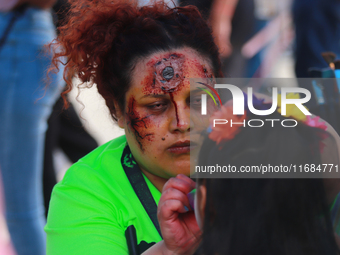 A woman applies makeup to a person during the annual Zombie Walk 2024 Mx, from the Monument to the Revolution to the main square Zocalo in M...