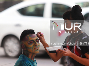 A woman applies makeup to a person during the annual Zombie Walk 2024 Mx, from the Monument to the Revolution to the main square Zocalo in M...