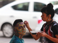 A woman applies makeup to a person during the annual Zombie Walk 2024 Mx, from the Monument to the Revolution to the main square Zocalo in M...