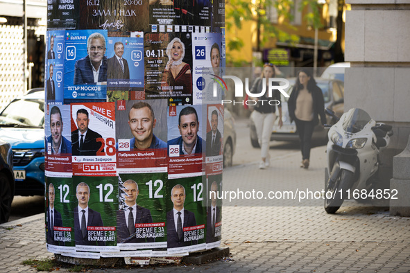 People walk past pre-election posters of parties and coalitions in Sofia, Bulgaria, on October 16, 2024. Bulgaria holds an early parliamenta...