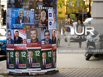 People walk past pre-election posters of parties and coalitions in Sofia, Bulgaria, on October 16, 2024. Bulgaria holds an early parliamenta...