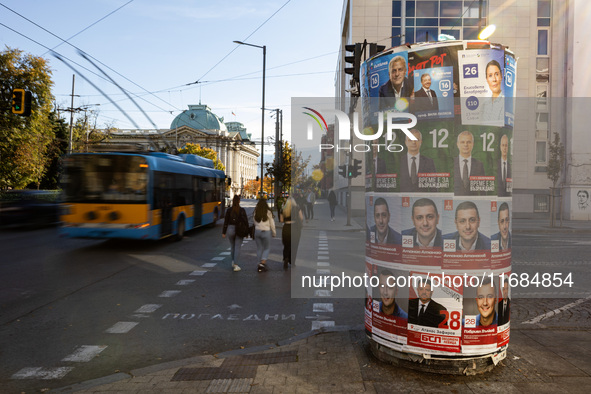 People walk past pre-election posters of parties and coalitions in Sofia, Bulgaria, on October 16, 2024. Bulgaria holds an early parliamenta...