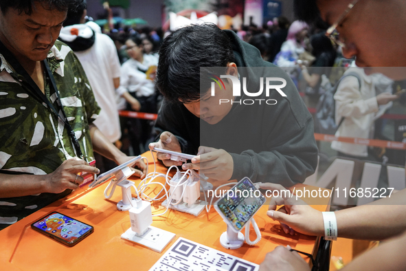 Gamers play video games on mobile phones at the Thailand Game Show 2024 in Bangkok, Thailand, on October 20, 2024. The Thailand Game Show 20...