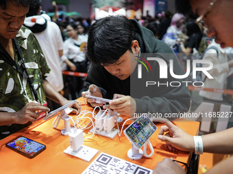 Gamers play video games on mobile phones at the Thailand Game Show 2024 in Bangkok, Thailand, on October 20, 2024. The Thailand Game Show 20...