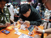 Gamers play video games on mobile phones at the Thailand Game Show 2024 in Bangkok, Thailand, on October 20, 2024. The Thailand Game Show 20...