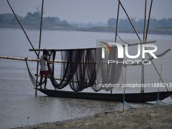 A fisherman arranges his fishing net on the Brahmaputra River in Mayong, Morigaon District, Assam, India, on October 20, 2024. (