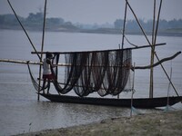 A fisherman arranges his fishing net on the Brahmaputra River in Mayong, Morigaon District, Assam, India, on October 20, 2024. (