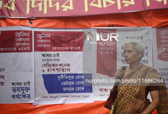 A woman passes next to the banner of junior doctors demanding justice and safety in hospitals at a protest site in Kolkata, India, on Octobe...