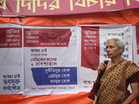 A woman passes next to the banner of junior doctors demanding justice and safety in hospitals at a protest site in Kolkata, India, on Octobe...