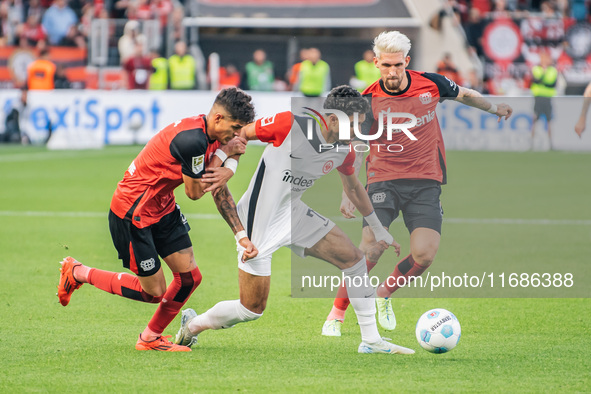 Omar Marmoush of Eintracht Frankfurt plays against Piero Hincapie and Robert Andrich of Bayer 04 Leverkusen during the Bundesliga match betw...