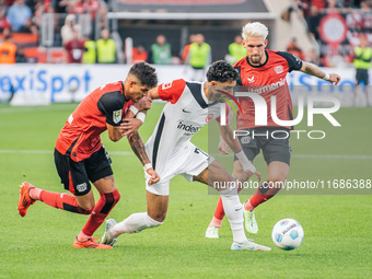 Omar Marmoush of Eintracht Frankfurt plays against Piero Hincapie and Robert Andrich of Bayer 04 Leverkusen during the Bundesliga match betw...