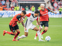 Omar Marmoush of Eintracht Frankfurt plays against Piero Hincapie and Robert Andrich of Bayer 04 Leverkusen during the Bundesliga match betw...