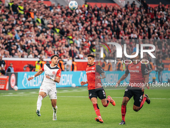 Omar Marmoush of Eintracht Frankfurt plays against Piero Hincapie and Jonathan Tah of Bayer 04 Leverkusen during the Bundesliga match betwee...