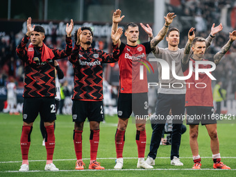 Xabi Alonso, Head Coach of Bayer 04 Leverkusen, and his players celebrate with fans after the Bundesliga match between Bayer 04 Leverkusen a...