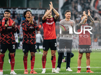 Xabi Alonso, Head Coach of Bayer 04 Leverkusen, and his players celebrate with fans after the Bundesliga match between Bayer 04 Leverkusen a...