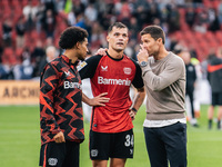 Xabi Alonso, Head Coach of Bayer 04 Leverkusen, speaks with Granit Xhaka and Amine Adli after the Bundesliga match between Bayer 04 Leverkus...