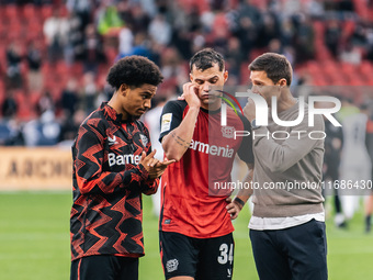 Xabi Alonso, Head Coach of Bayer 04 Leverkusen, speaks with Granit Xhaka and Amine Adli after the Bundesliga match between Bayer 04 Leverkus...