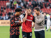 Xabi Alonso, Head Coach of Bayer 04 Leverkusen, speaks with Granit Xhaka and Amine Adli after the Bundesliga match between Bayer 04 Leverkus...