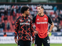 Granit Xhaka of Bayer 04 Leverkusen speaks with his teammate Amine Adli after the Bundesliga match between Bayer 04 Leverkusen and Eintracht...