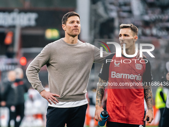 Xabi Alonso, Head Coach of Bayer 04 Leverkusen, and Alejandro Grimaldo of Bayer 04 Leverkusen celebrate with fans after the Bundesliga match...