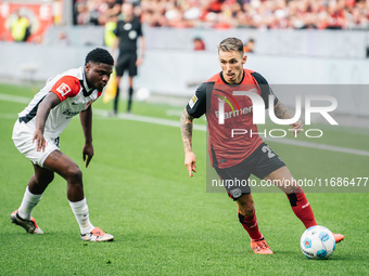 Alejandro Grimaldo of Bayer 04 Leverkusen plays against Junior Dina Ebimbe of Eintracht Frankfurt during the Bundesliga match between Bayer...