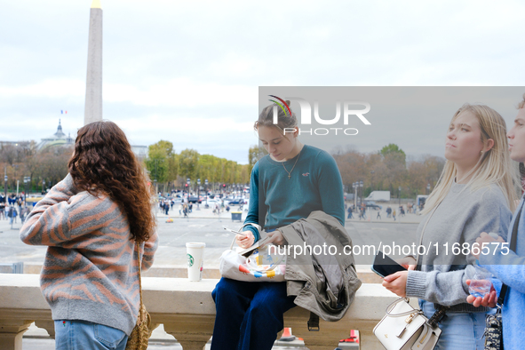 A One Direction fan writes a note for the makeshift memorial to Liam Payne in the Tuileries Gardens in Paris, France. 