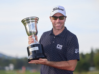 Julien Guerrier of France poses with the trophy on the 18th green following victory in a nine-hole play-off during day four of the Estrella...